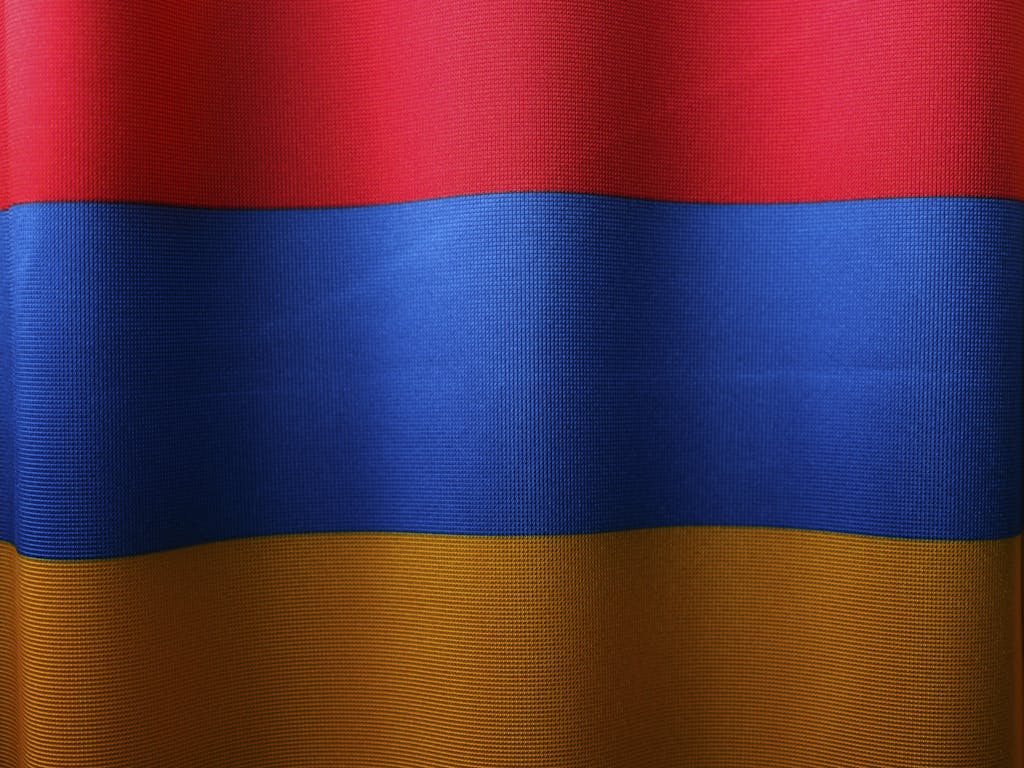 Close-up of the colorful Armenian flag with red, blue, and orange stripes symbolizing national pride.